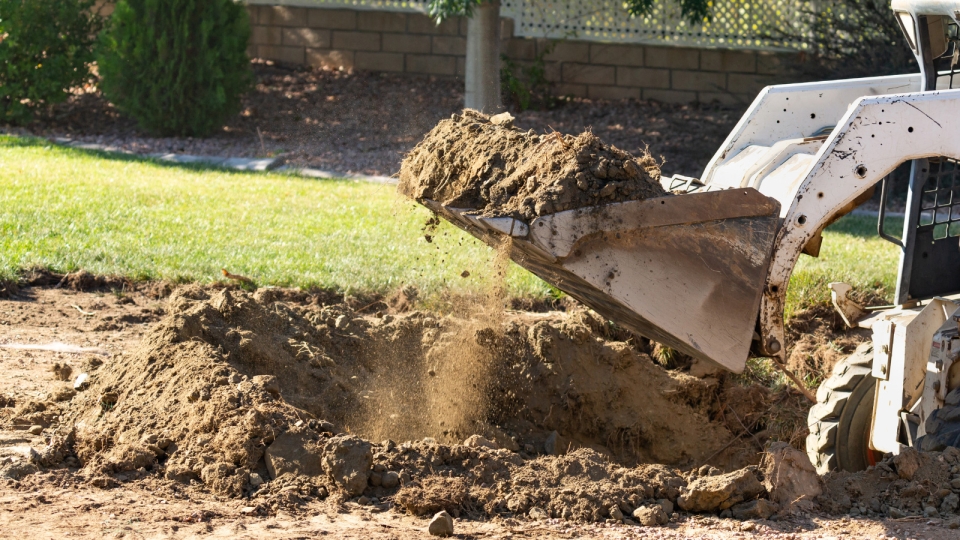 skid steerer digging in backyard
